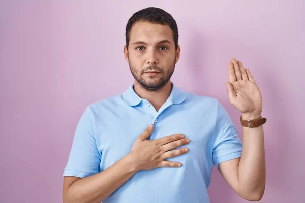 Hispanic Man Standing Pink Background Swearing Hand Chest Open Palm — Stock Photo, Image