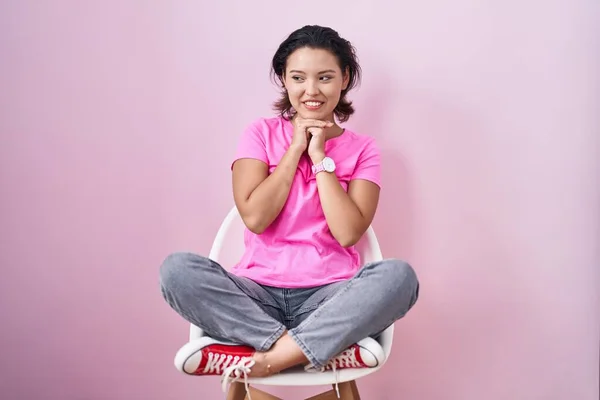 Spaanse Jonge Vrouw Zitten Stoel Roze Achtergrond Lachen Nerveus Opgewonden — Stockfoto