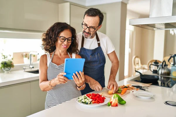 Pareja Hispana Mediana Edad Sonriendo Confiada Cocinando Usando Touchpad Cocina —  Fotos de Stock
