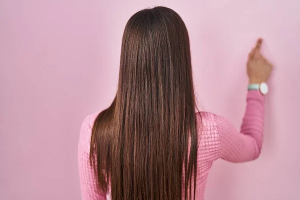 Young Hispanic Woman Standing Pink Background Posing Backwards Pointing Ahead — Fotografia de Stock
