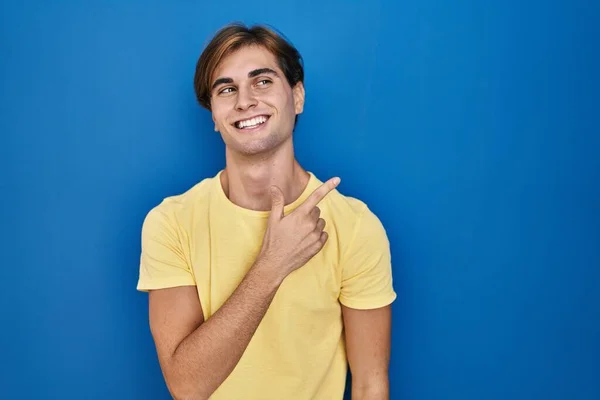 Молодий Чоловік Стоїть Над Синім Тлом Веселий Посмішкою Обличчя Спрямованою — стокове фото