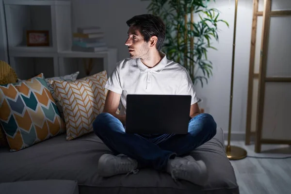 Homem Hispânico Jovem Usando Laptop Casa Noite Olhando Para Lado — Fotografia de Stock