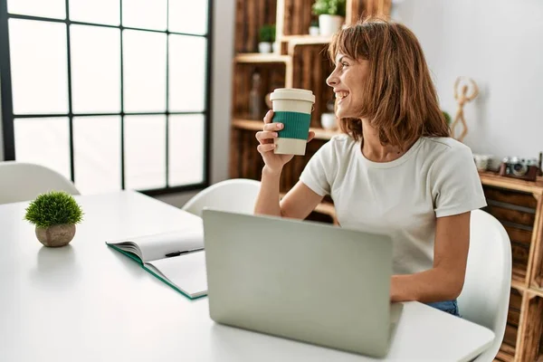 Νεαρή Καυκάσια Γυναίκα Που Χρησιμοποιεί Φορητό Υπολογιστή Πίνοντας Καφέ Καθισμένη — Φωτογραφία Αρχείου