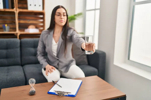 若い美しいパニック女性の心理学者は 心理学クリニックで水のガラスを提供します — ストック写真