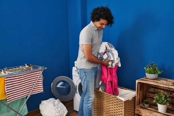 若いヒスパニック系の男は洗濯室で自信を持って洗濯服を笑って — ストック写真