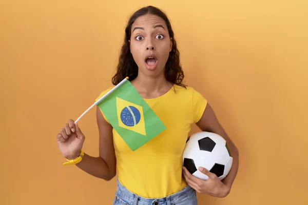 Молодая Латиноамериканка Держащая Руках Бразильский Флаг Футбольный Мяч Напугана Потрясена — стоковое фото