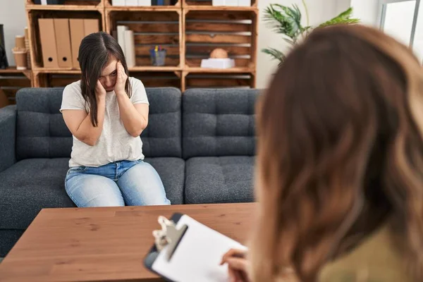 stock image Hispanic girl with down syndrome doing therapy with hand on head for pain in head because stress. suffering migraine. 