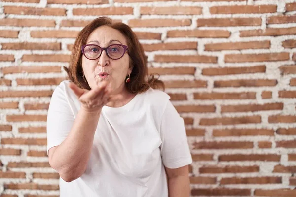 Mujer Mayor Con Gafas Pie Sobre Pared Ladrillos Mirando Cámara —  Fotos de Stock