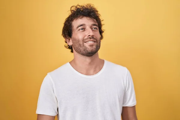 Mladý Hispánec Muž Usměvavý Sebevědomě Dívá Stranu Přes Izolované Žluté — Stock fotografie