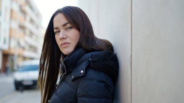 Young caucasian woman standing with serious expression at street