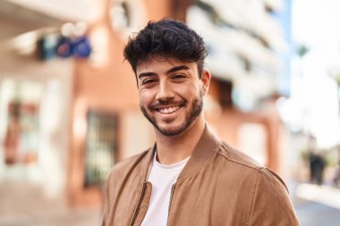 Sokakta kendinden emin gülümseyen İspanyol genç adam.