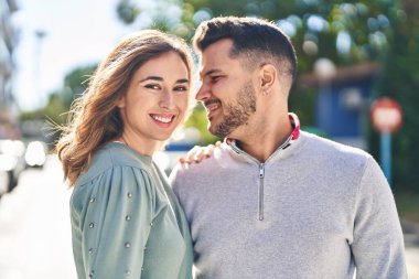 Man and woman smiling confident hugging each other standing at street