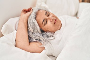 Middle age woman sleeping lying on bed at bedroom