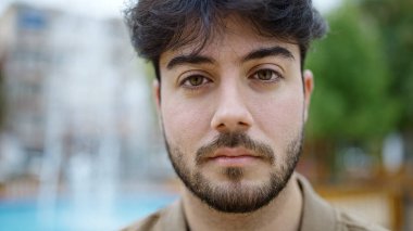 Parkta rahat bir ifadeyle duran genç İspanyol adam.