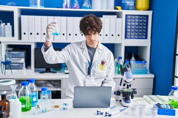 Young Hispanic Man Scientist Using Laptop Measuring Liquid Laboratory — Stock fotografie