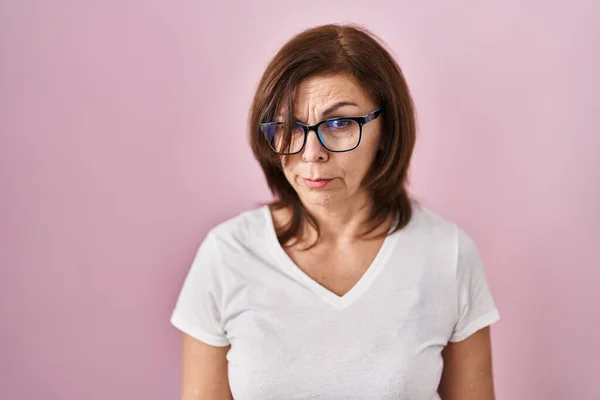ピンクの背景懐疑的で神経の上に立っている中年のパニック女性は 問題のために動揺を眉をひそめている 否定的な人 — ストック写真