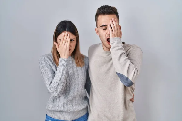 Young Hispanic Couple Standing White Background Yawning Tired Covering Half —  Fotos de Stock