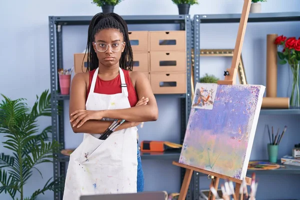 年轻的非洲裔美国人 画室里的辫子画在画布的怀疑和紧张 不赞成脸上的表情与交叉的胳膊 消极的人 — 图库照片