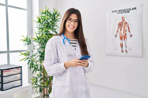 Νεαρή Όμορφη Ισπανόφωνη Γυναίκα Γιατρός Χαμογελά Αυτοπεποίθηση Χρησιμοποιώντας Smartphone Στην — Φωτογραφία Αρχείου