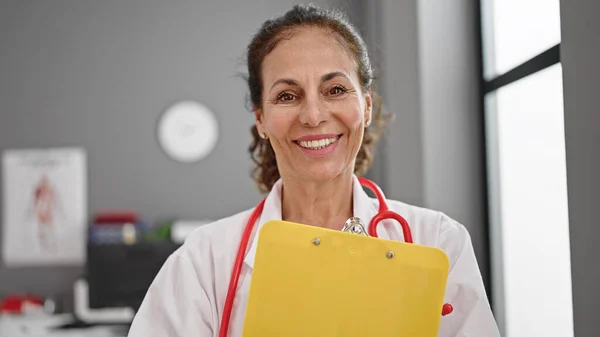 Středního Věku Hispánská Žena Lékař Usmívá Sebevědomě Držení Schránky Klinice — Stock fotografie
