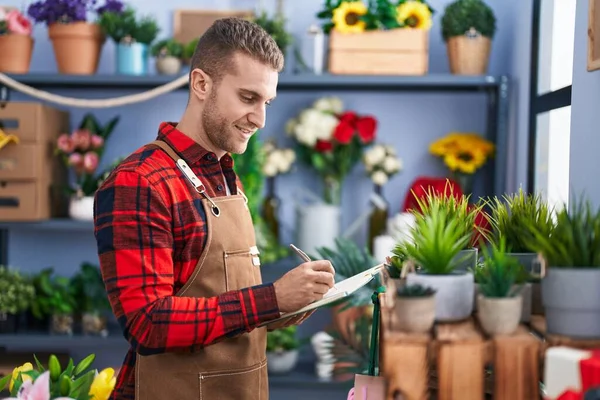 Joven Florista Hombre Caucásico Sonriendo Escritura Segura Cuaderno Tienda Flores — Foto de Stock