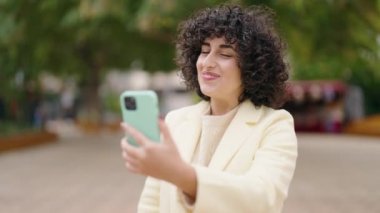 Young woman smiling confident having video call at park