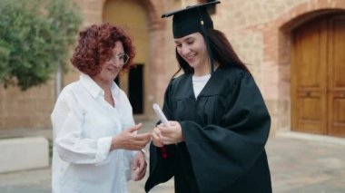 İki kadın anne ve kız kampüs üniversitesinde diploma okuyorlar.