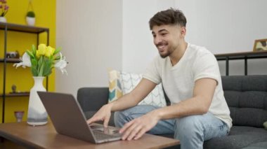 Genç Arap 'ın evdeki kanepede otururken görüntülü konuşması var.