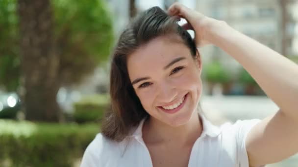 Νεαρή Ισπανίδα Γυναίκα Χαμογελά Σίγουρη Χτένισμα Μαλλιών Χέρι Στο Πάρκο — Αρχείο Βίντεο