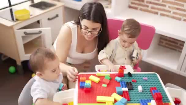 Anaokulunda Masada Oturan Çocuklarla Oynayan Bir Öğretmen — Stok video