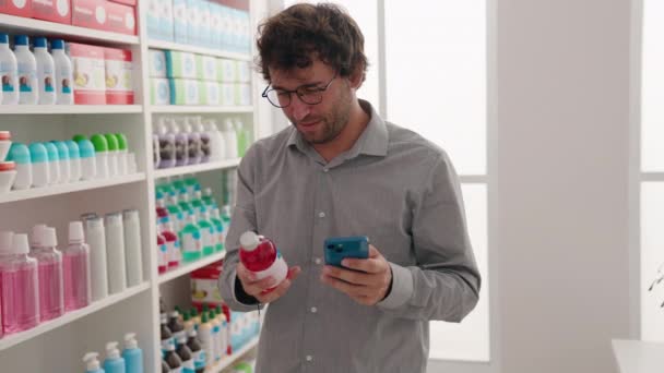 Joven Cliente Hispano Usando Teléfono Inteligente Sosteniendo Una Botella Medicina — Vídeo de stock