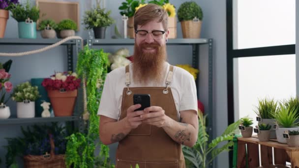 Young Redhead Man Florist Smiling Confident Using Smartphone Flower Shop — Stockvideo