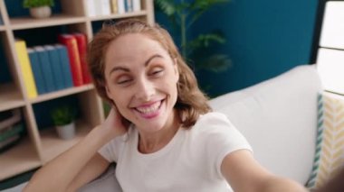 Genç, güzel İspanyol bir kadın evdeki kanepede otururken görüntülü konuşma yapıyor.