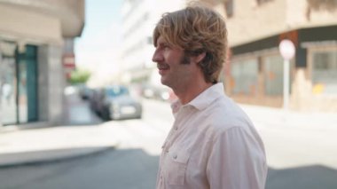 Sokakta kendine güvenen genç adam gülümsüyor