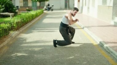 Genç İspanyol adam parkta karate dövüşçüsü eğitimi alıyor.
