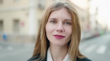 Young caucasian woman with relaxed expression standing at street