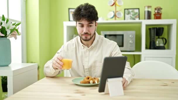 Jovem Hispânico Tomando Café Manhã Assistindo Vídeo Touchpad Sala Jantar — Vídeo de Stock