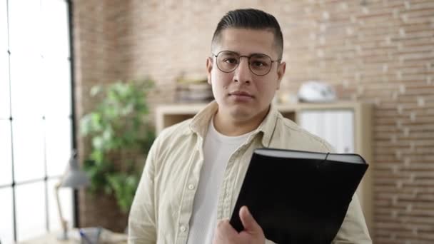若いヒスパニック系の男のビジネスワーカーは オフィスに立ってバインダーを保持 — ストック動画