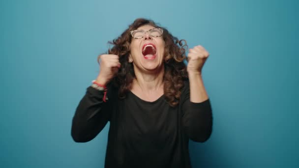 Mujer Mediana Edad Sonriendo Confiado Pie Celebrando Sobre Fondo Azul — Vídeo de stock