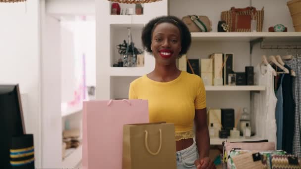 アフリカ系アメリカ人女性ショップアシスタントが衣料品店でクレジットカードを保持 — ストック動画
