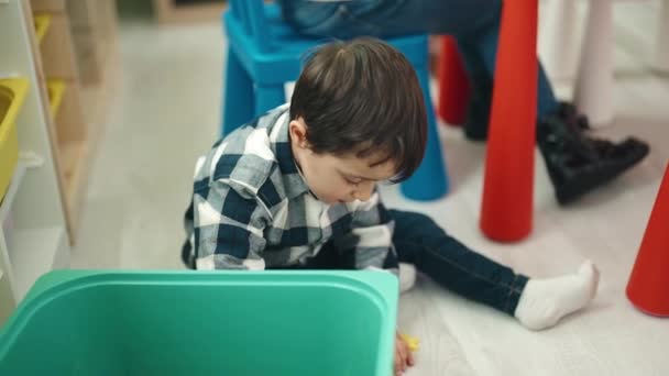 Förtjusande Latinamerikansk Pojke Som Håller Leksaker Kub Sittande Golvet Dagis — Stockvideo
