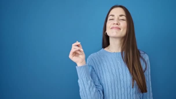 Молода Біла Жінка Посміхається Вказуючи Бік Ізольованого Синього Фону — стокове відео