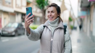 Middle age woman smiling confident having video call at street