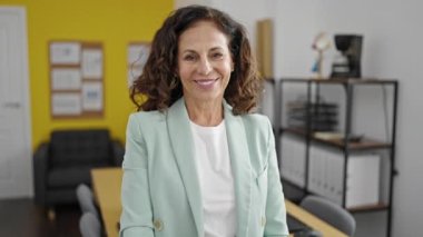 Orta yaşlı İspanyol iş kadını gülümseyen kendine güvenen bir işadamı ofiste tokalaşıyor.