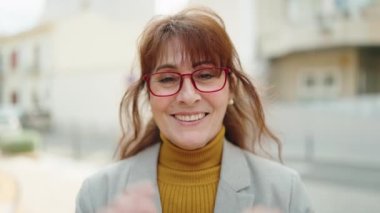 Middle age woman business executive smiling confident at street