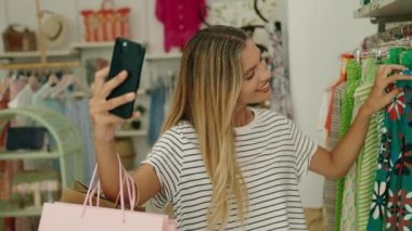 Young blonde woman customer smiling confident having video call at clothing store