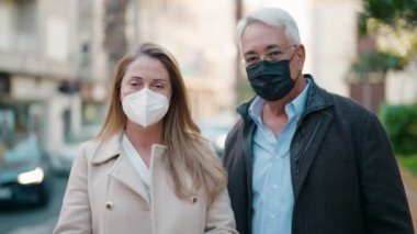 Sokakta maske takan orta yaşlı çift