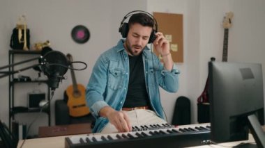 Genç İspanyol adam müzik stüdyosunda şarkı söyleyip dans ediyor.