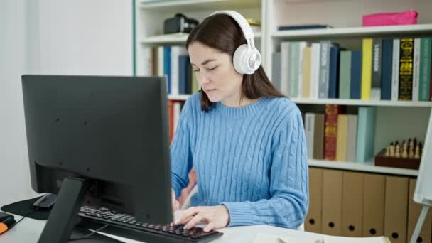 Νεαρή Καυκάσια Φοιτήτρια Που Χρησιμοποιεί Υπολογιστή Και Ακουστικά Και Αναπαύεται — Αρχείο Βίντεο