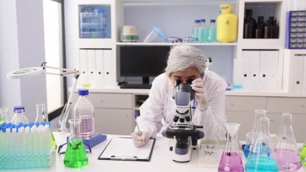Middle Age Grey Haired Woman Wearing Scientist Uniform Using Microscope — Stockvideo